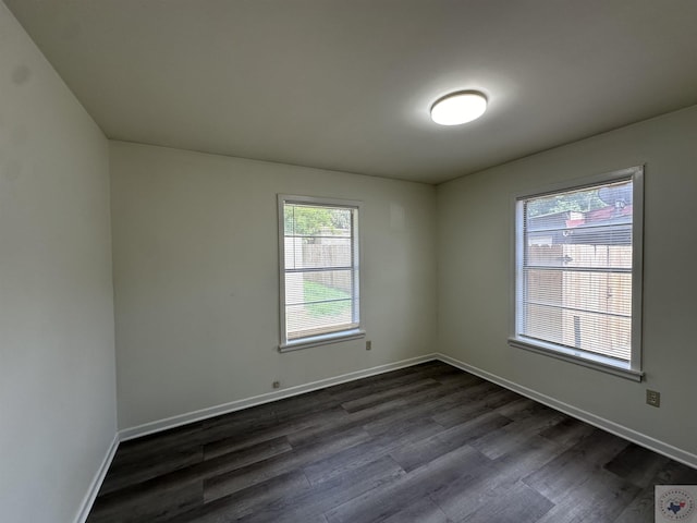 empty room with plenty of natural light and dark wood-type flooring