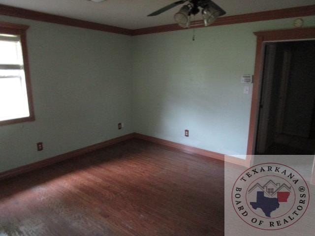 empty room with hardwood / wood-style flooring, crown molding, and ceiling fan