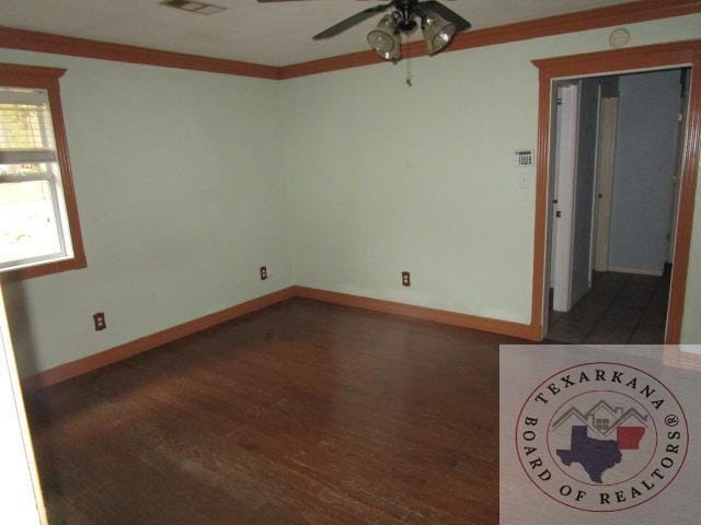 empty room featuring ceiling fan, dark hardwood / wood-style floors, and crown molding