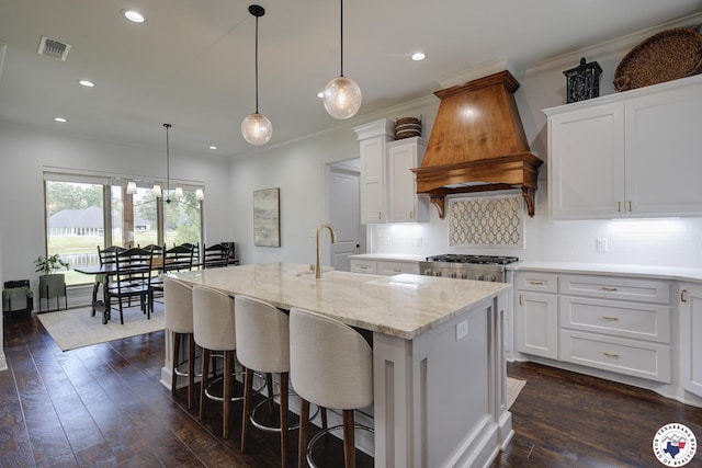 8203 Teal Rd, Texarkana, TX 75503 - kitchen featuring custom range hood, a center island with sink, white cabinetry, recessed lighting, and ornamental molding