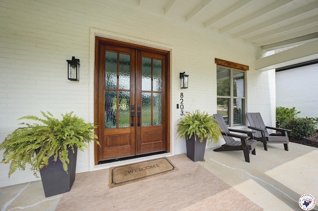 8203 Teal Rd, Texarkana, TX 75503 - view of exterior entry with french doors, covered porch, and brick siding