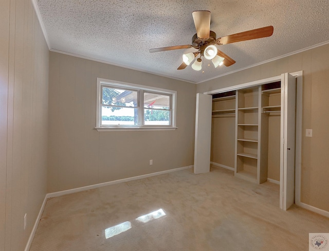 unfurnished bedroom with crown molding, light colored carpet, a textured ceiling, and ceiling fan