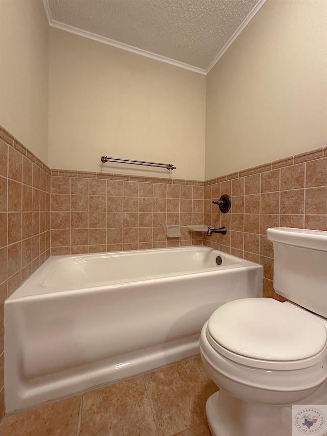 bathroom featuring tile walls, toilet, a bathing tub, and a textured ceiling