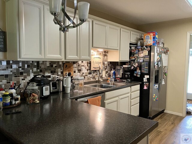 kitchen with stainless steel appliances, backsplash, white cabinetry, and light hardwood / wood-style flooring