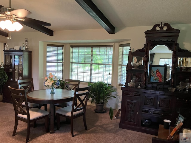 dining area featuring beamed ceiling and carpet floors