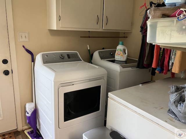 laundry room with hardwood / wood-style floors, cabinets, and washer and dryer