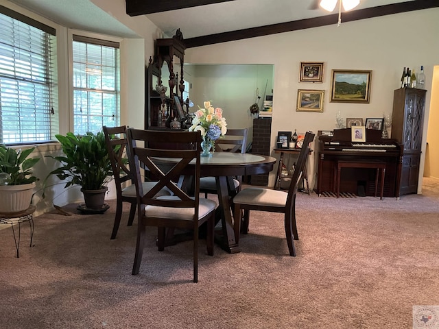 carpeted dining area with vaulted ceiling with beams