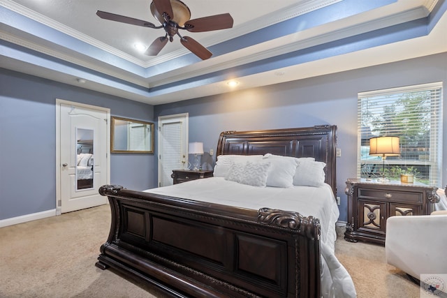 carpeted bedroom with ceiling fan, a raised ceiling, and ornamental molding