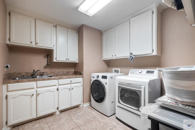 laundry room featuring sink, washing machine and dryer, light tile patterned floors, and cabinets