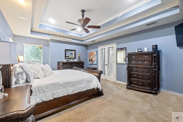 carpeted bedroom featuring ceiling fan, french doors, a raised ceiling, and ornamental molding