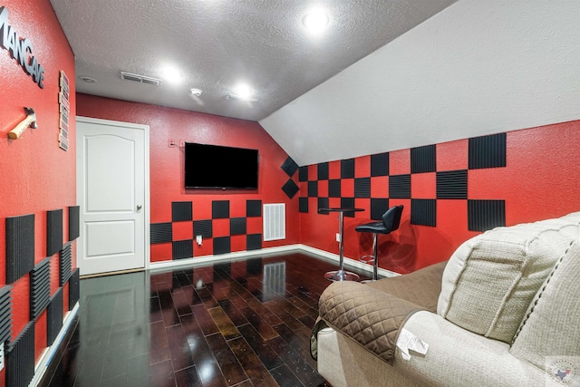 interior space with a textured ceiling and lofted ceiling