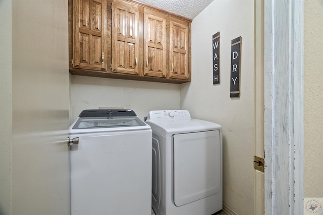 laundry room featuring cabinets, independent washer and dryer, and a textured ceiling