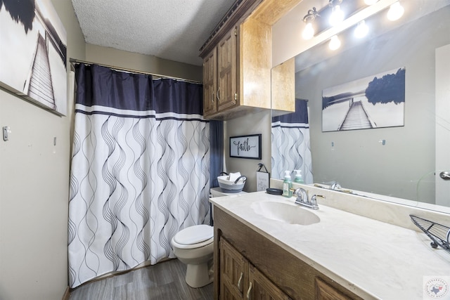 bathroom featuring vanity, hardwood / wood-style floors, toilet, and a textured ceiling