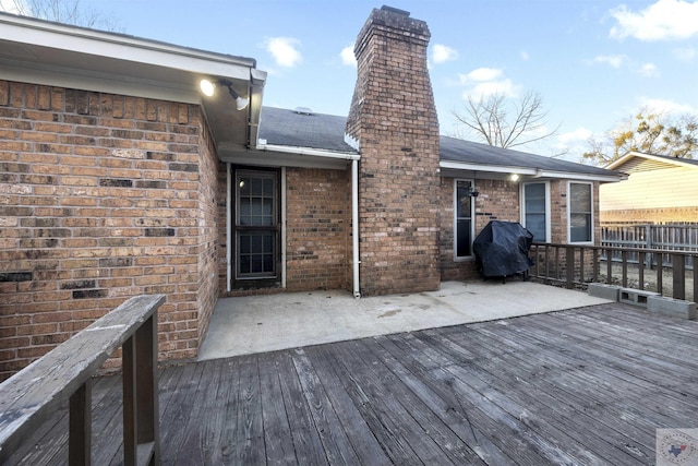 wooden deck featuring a patio and a grill