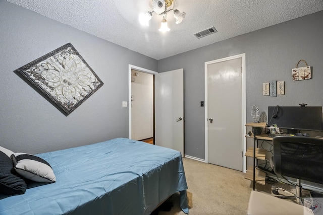 bedroom featuring light colored carpet and a textured ceiling