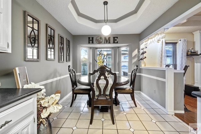 dining space with crown molding, a raised ceiling, and a textured ceiling