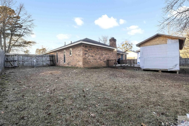 rear view of house with a yard and a deck