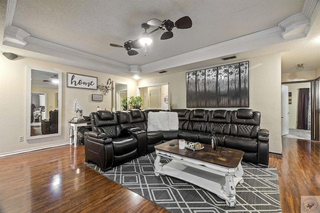 living room with dark hardwood / wood-style flooring, ceiling fan, a raised ceiling, and a textured ceiling