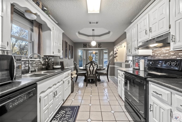 kitchen with black appliances, white cabinetry, sink, a tray ceiling, and a textured ceiling