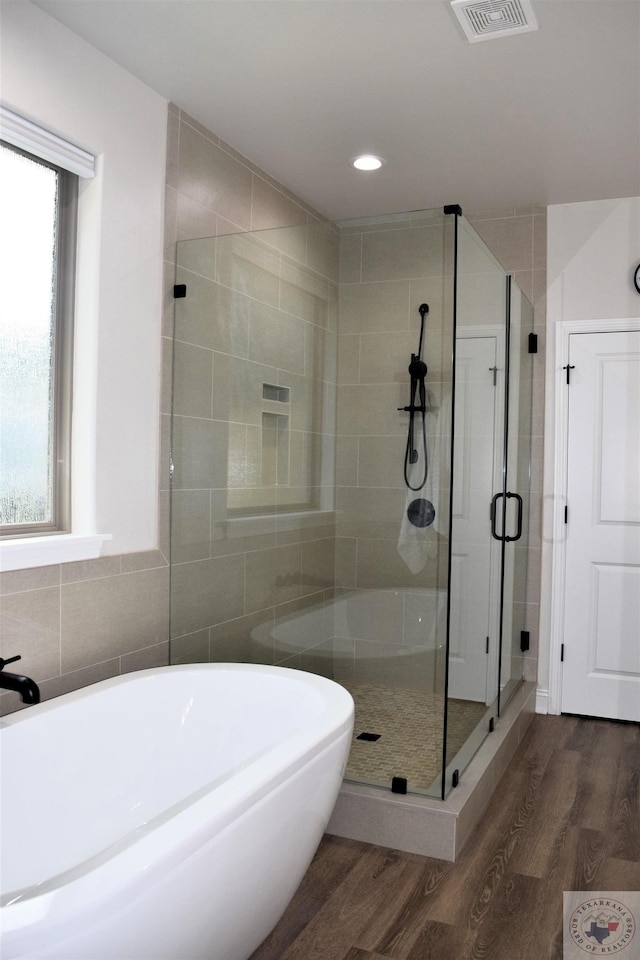 bathroom with separate shower and tub and wood-type flooring