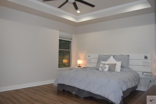 bedroom featuring ceiling fan, a raised ceiling, ornamental molding, and dark wood-type flooring