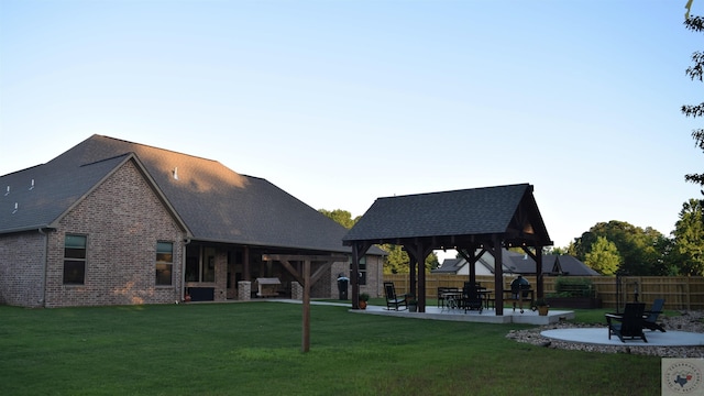 rear view of house with a gazebo, a yard, and a patio