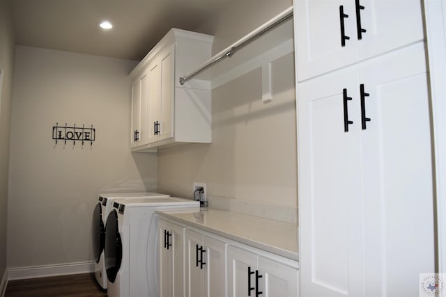 laundry area featuring washing machine and dryer, dark hardwood / wood-style floors, and cabinets