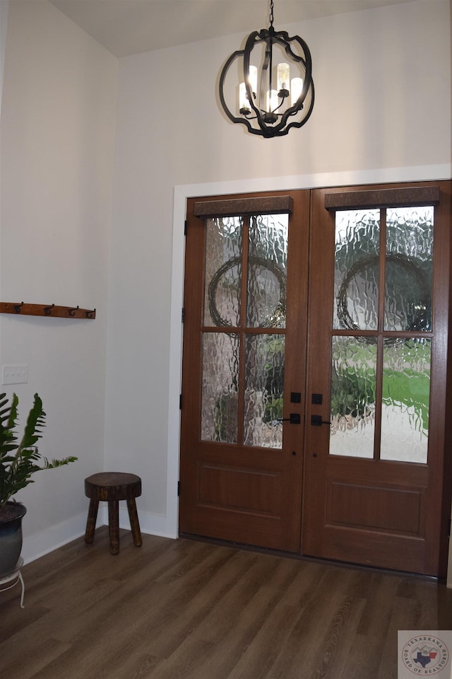 entrance foyer featuring dark wood-type flooring, a notable chandelier, and french doors