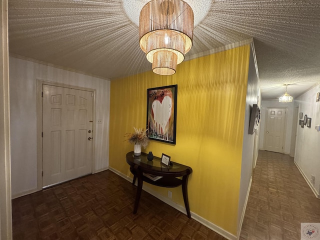 hall with dark parquet floors, a textured ceiling, and an inviting chandelier