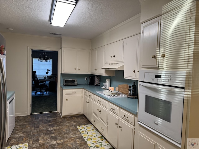 kitchen featuring white cabinetry, white appliances, and a textured ceiling