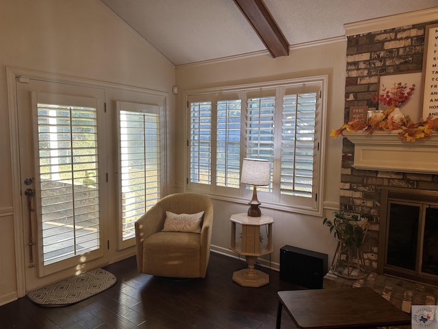 sitting room with wood-type flooring, lofted ceiling with beams, a healthy amount of sunlight, and a fireplace