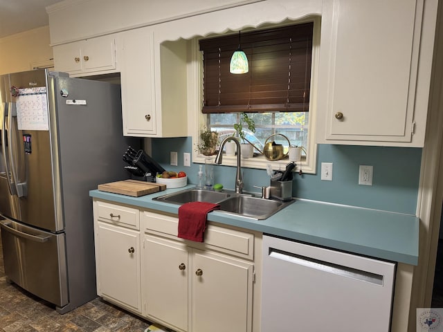 kitchen featuring sink, stainless steel appliances, white cabinets, and pendant lighting