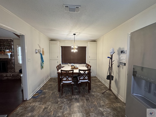 dining space with crown molding, a textured ceiling, and a brick fireplace