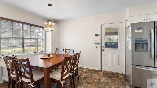 dining area featuring ornamental molding, plenty of natural light, baseboards, and stone finish flooring