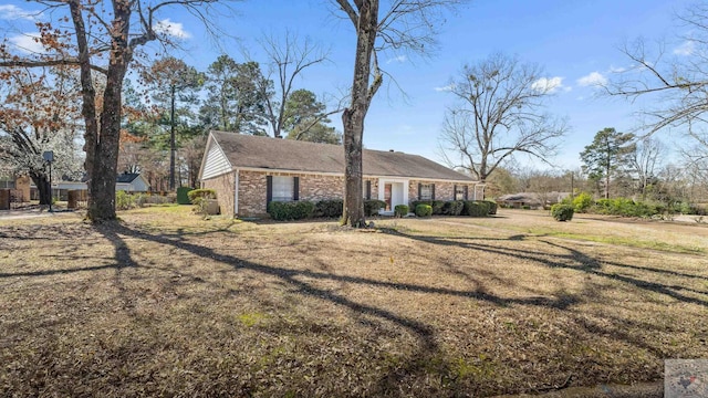 ranch-style house featuring brick siding and a front yard