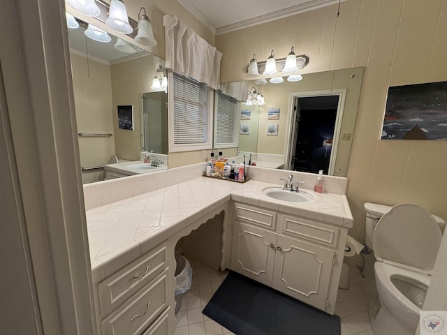 bathroom featuring toilet, tile patterned flooring, vanity, and ornamental molding