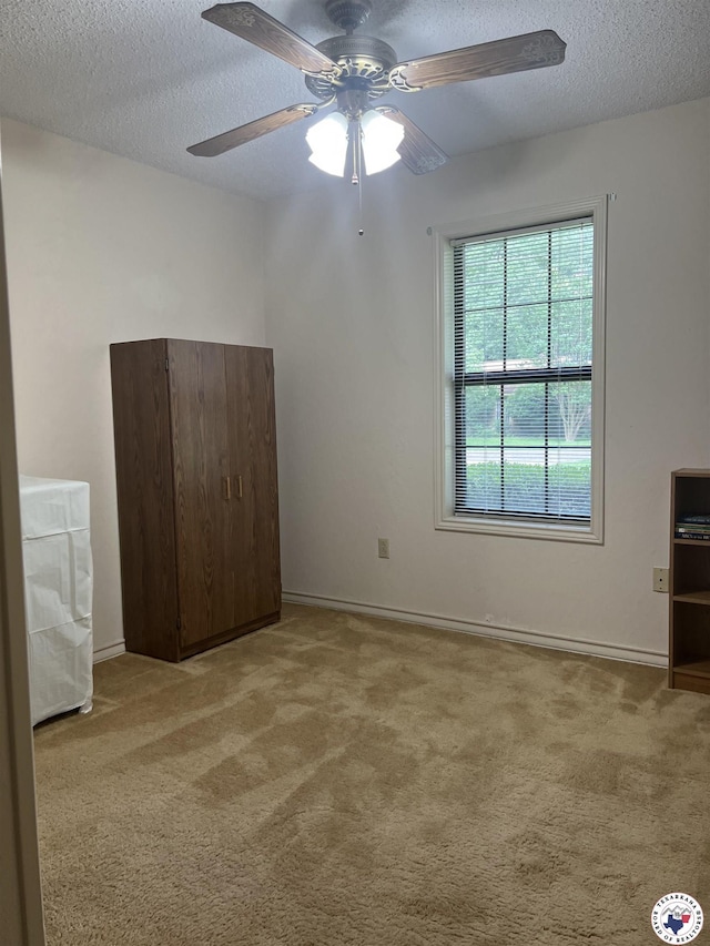 713 Franklin St, Texarkana, TX 75501 - unfurnished bedroom with carpet, a textured ceiling, baseboards, and ceiling fan