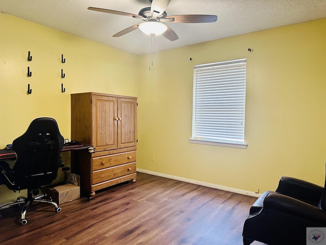 office space with ceiling fan, baseboards, dark wood finished floors, and a textured ceiling