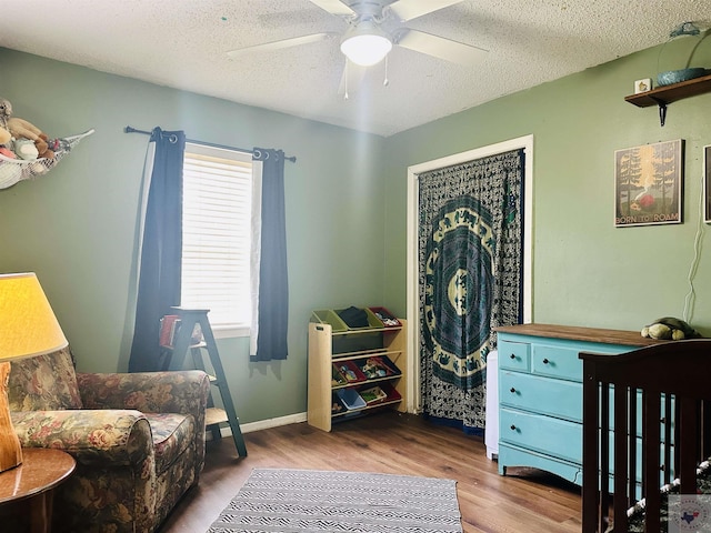 bedroom with ceiling fan, a textured ceiling, and wood finished floors