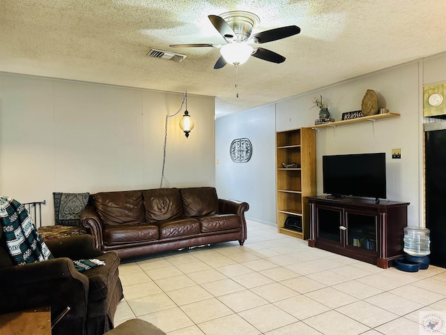 living area with light tile patterned floors, a textured ceiling, visible vents, and a ceiling fan