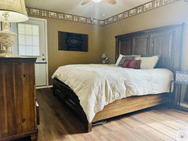 bedroom with ceiling fan, a textured ceiling, and wood finished floors