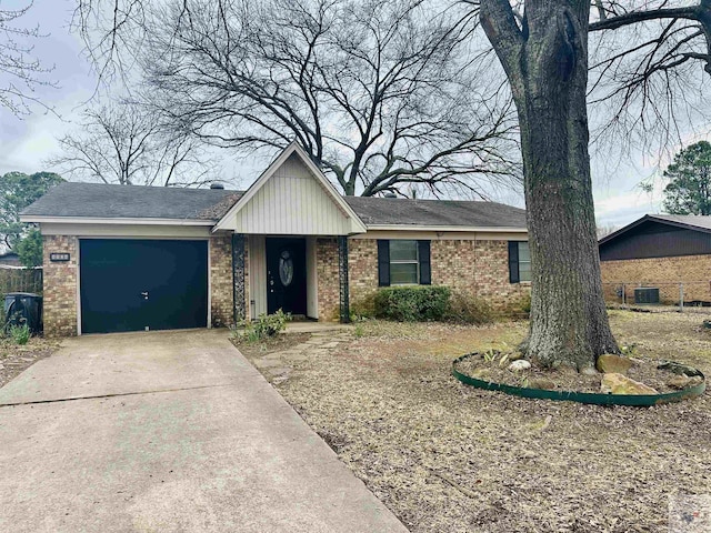 single story home featuring concrete driveway, brick siding, and an attached garage