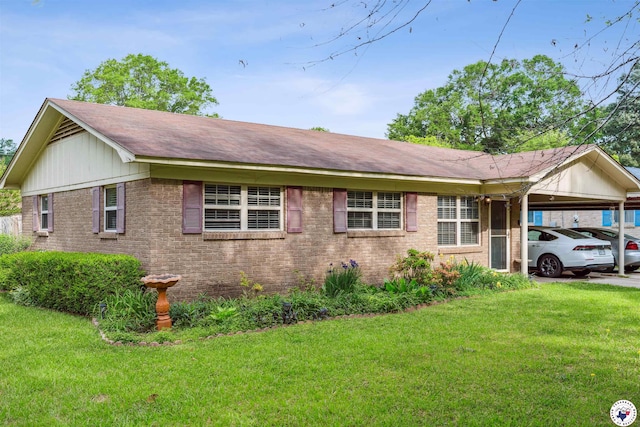 view of front of home with brick siding, an attached carport, roof with shingles, and a front yard
