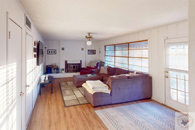 living room featuring a wealth of natural light, a textured ceiling, and light wood-type flooring