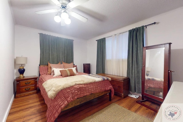 bedroom featuring crown molding, hardwood / wood-style flooring, a textured ceiling, and ceiling fan