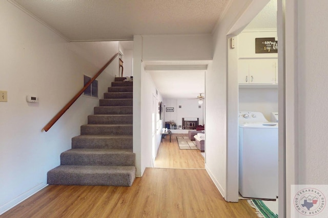 interior space with crown molding, hardwood / wood-style floors, washer / dryer, and a textured ceiling