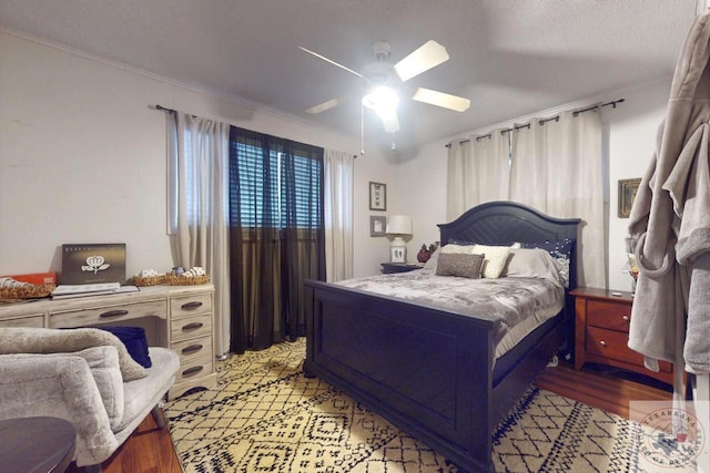 bedroom featuring crown molding, a textured ceiling, ceiling fan, and light hardwood / wood-style floors