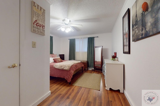 bedroom with ceiling fan, wood-type flooring, and a textured ceiling