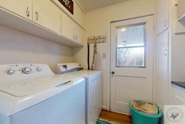 laundry room with crown molding, cabinets, wood-type flooring, and washing machine and dryer