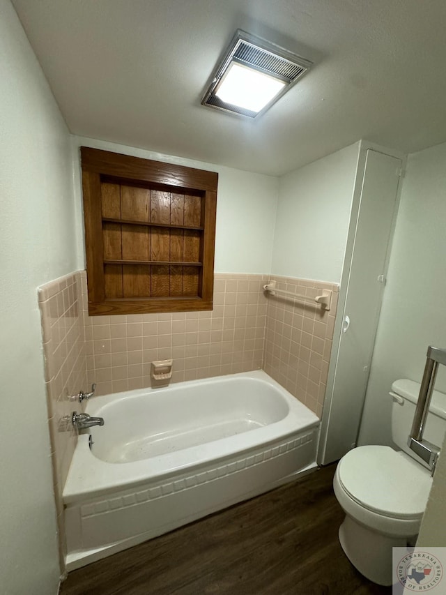 bathroom featuring a washtub, wood-type flooring, and toilet